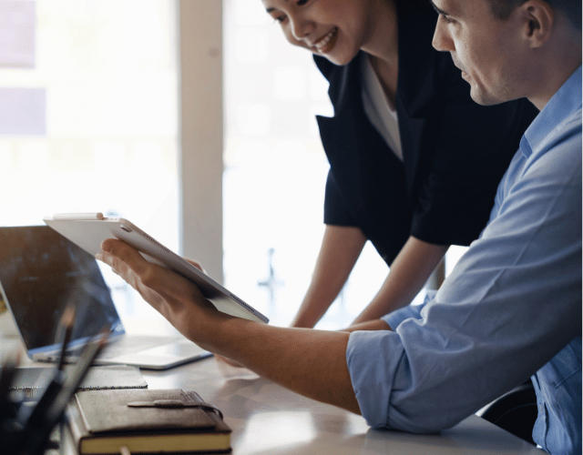 Male and female discussing financial projections on a tablet