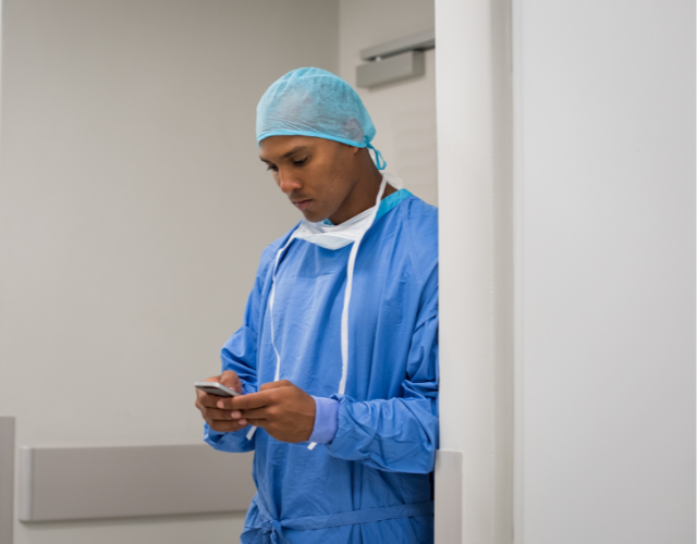Male doctor on mobile phone in hospital corridor