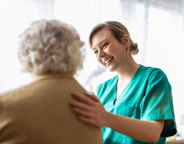 Friendly nurse supporting an elderly lady