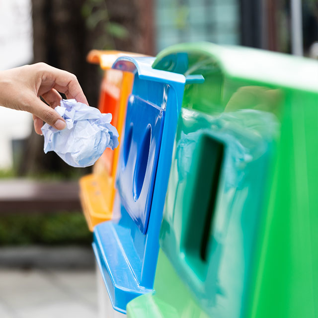 Closeup portrait woman hand throwing crumpled paper in recycling bin.