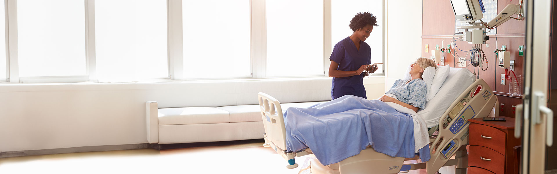 health-framework-agreement-banner doctor talking to patent in a hospital bed